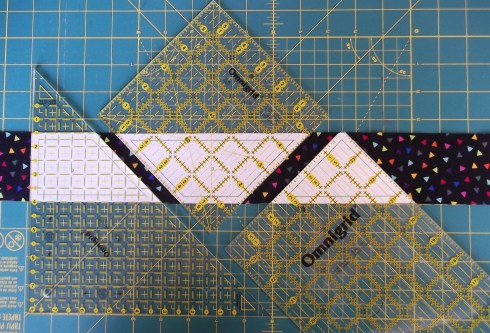 Tape paper templates to the underside of a ruler and cut along edges of ruler to cut the pieces.