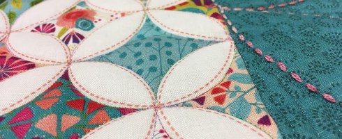 A close-up of the Forest Frolic cathedral window fabric in my quilt